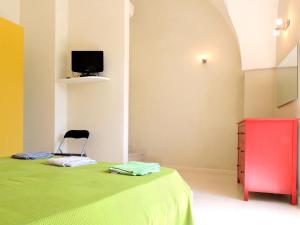 迪索Oikia Vacanze Diso Giulia的一间卧室配有绿色的床和红色梳妆台