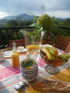 西布勒Villa La Croix Basque的一张桌子,上面放着一碗水果和一瓶果汁