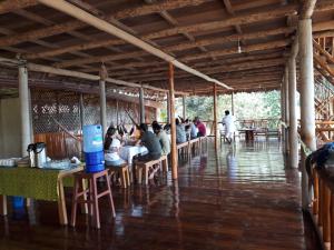 TambopataTres Chimbadas Lake Lodge的一群坐在餐厅桌子上的人