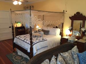 纳奇兹Magnolia Cottage Bed and Breakfast的一间卧室配有一张带天蓬的床