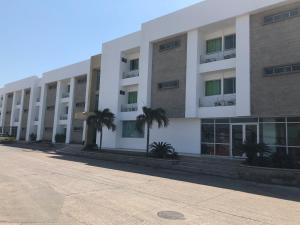 巴兰基亚Hotel Via 40的一座白色的大建筑,前面有棕榈树