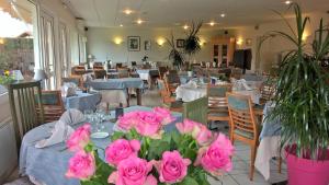 Bas-Mauco埃里奥斯餐厅酒店的餐厅设有粉红色玫瑰花桌