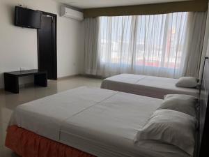 巴兰基亚Hotel Via 40的酒店客房设有两张床和一台平面电视。
