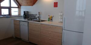 米湖斯库图斯塔德农家乐的厨房配有白色冰箱和木制橱柜。