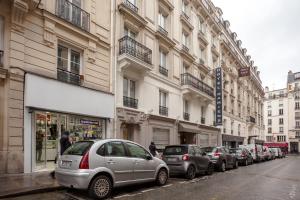 巴黎艾米安酒店的停在建筑物旁边的街道上的一排汽车