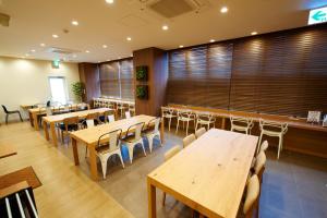 奈良JR奈良站前三条通超级酒店的用餐室配有木桌和椅子