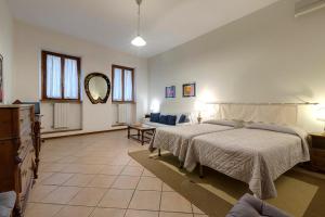 佛罗伦萨阿蒂利奥公寓的一间大卧室,配有两张床和镜子