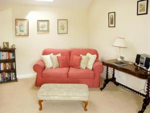 毕晓普斯堡The Byre的客厅配有红色的沙发和桌子