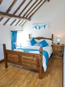 阿贝尔格莱Beudy Bach的一间卧室配有一张带蓝色枕头的木床。