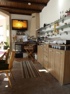 摩泽尔河畔的泽尔B&B Pension Winzerhaus Zell-Mosel的厨房配有木制橱柜和墙上的电视。