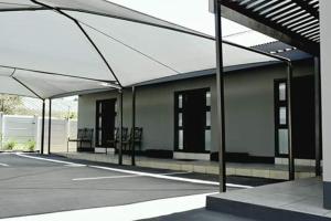 布隆方丹Ehrlichpark Lodge self catering and spa的空的停车场,有屋顶的建筑