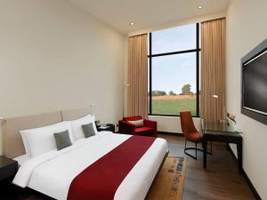 拜拉哈瓦Tiger Palace Resort的一间卧室设有一张大床和一个大窗户