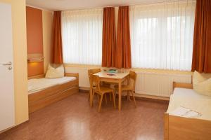 德累斯顿DJH 德累斯顿青年旅舍 - 青年旅舍的客房设有桌子、床和桌椅。
