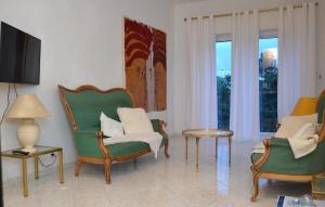 尼斯Les Grands Cedres的客厅配有椅子和桌子,设有窗户