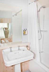 Feetham旁池碗旅馆的白色的浴室设有水槽和淋浴。