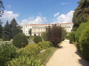 尼斯Les Grands Cedres的一座白色的大建筑,前面有一个花园