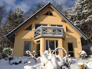 赛巴特班森Ferienwohnung Amelie的雪中的黄色房子