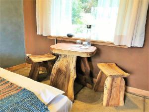 普孔Elementos Eco Lodge的窗户旁的房间,配有一张桌子和两张凳子
