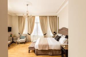 雅典雅典大厦豪华套房酒店的一间卧室配有一张床、一张桌子和一把椅子