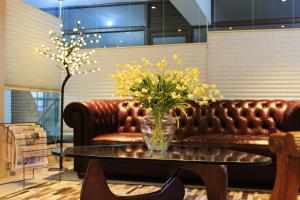 奇廉拉斯特拉萨斯商务酒店的一张桌子上装有黄色花朵的玻璃花瓶