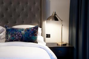 雷克雅未克Sand Hotel by Keahotels的一间卧室配有一张带枕头和灯的床