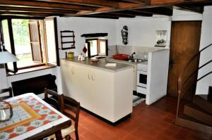LelgioRustico Gola di Lago的厨房配有水槽、冰箱和桌子