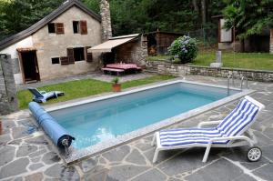 LelgioRustico Gola di Lago的一个带2把躺椅的游泳池以及1栋房子