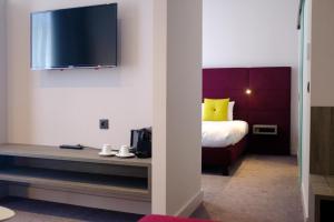 布鲁塞尔马里伏酒店的一间设有床铺和墙上电视的客房