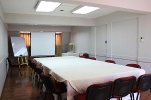奇廉拉斯特拉扎快捷酒店的一间会议室,配有一张白色的大桌子和椅子