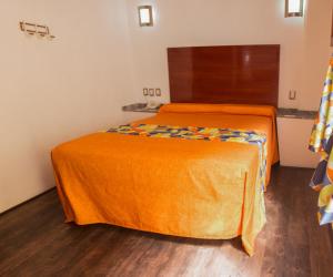 帕丘卡德索托Las Avenidas的两张带橙色床单的床