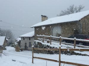 拉卡佩勒－维耶斯康La Grange du Lac de Cantalès的一座雪覆盖的房子,旁边停有一辆汽车