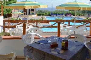 卡梅罗塔码头Villaggio La Siesta的一间带桌椅和游泳池的餐厅