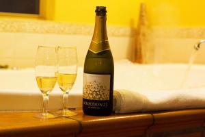 霍尔斯加普Marwood Villas的柜台上的一瓶香槟和两杯酒杯