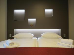 乌尔姆纽托尔酒店的两张带白色床单和枕头的床。