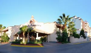 华雷斯城玛丽亚博尼塔商务套房酒店的一座楼前有棕榈树的酒店