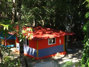 Isla Cebaco Cebaco Sunrise Lodge的树林里的一个红色的白色和蓝色的房子