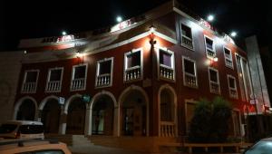 佩贡伊什Albergaria Malaposta的一座红色的大建筑,晚上有灯
