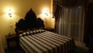 佩贡伊什Albergaria Malaposta的一间卧室配有一张带条纹毯子的床和窗户