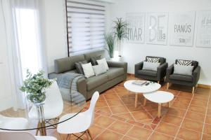 EsteponaApartment Design Marbella的客厅配有沙发、椅子和桌子