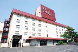 汤泽町汤泽新大谷日式旅馆的一座白色的大建筑,有红色的屋顶