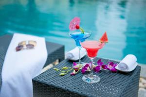 Tuyên Quang图岩况芒坦格兰德酒店的坐在泳池旁的桌子上,喝上两杯鸡尾酒
