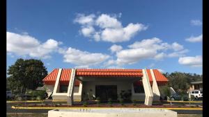 基西米企业汽车旅馆的停车场内一座带橙色屋顶的建筑