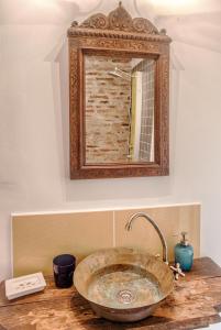 CloaşterfDominic Boutique - Gardener's Cottage的一间带石制水槽和镜子的浴室
