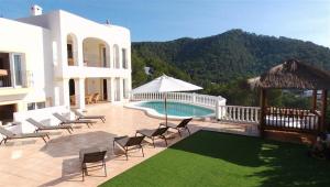 卡拉隆加Villa Sa Seni的一个带椅子的庭院、一个游泳池和一个房子