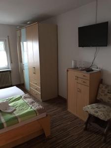 Eichelsdorf弗兰克特步公寓的一间卧室配有一张床、一个橱柜和一台电视