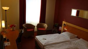 蒙绍ACHAT Hotel Monschau的酒店客房带一张床、一张桌子和椅子