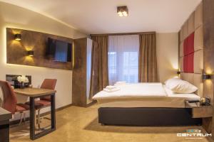 奥西耶克Centrum Osijek的酒店客房配有一张床铺和一张桌子。