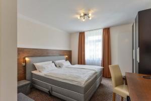菲尔特Hotel PrimaVera parco的配有一张床、一张桌子和一张桌子的酒店客房