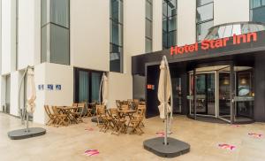 里斯本里斯本机场星辰酒店的配有桌椅和遮阳伞的酒店星级旅馆