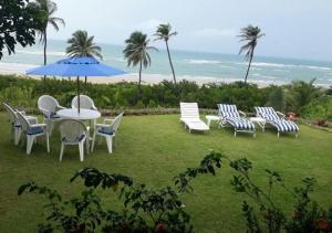 蒙达Casa de Praia em Mundaú的一组椅子和一张桌子及一把伞